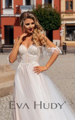 Lekka i subtelna suknia w delikatnym odcieniu nude z romantycznie opadającymi ramiączkami. Posiada pięknie wykończoną górę oraz zwiewny, tiulowy dół.