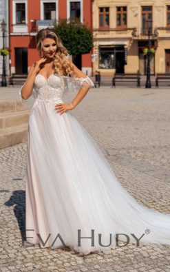 Lekka i subtelna suknia w delikatnym odcieniu nude z romantycznie opadającymi ramiączkami. Posiada pięknie wykończoną górę oraz zwiewny, tiulowy dół.