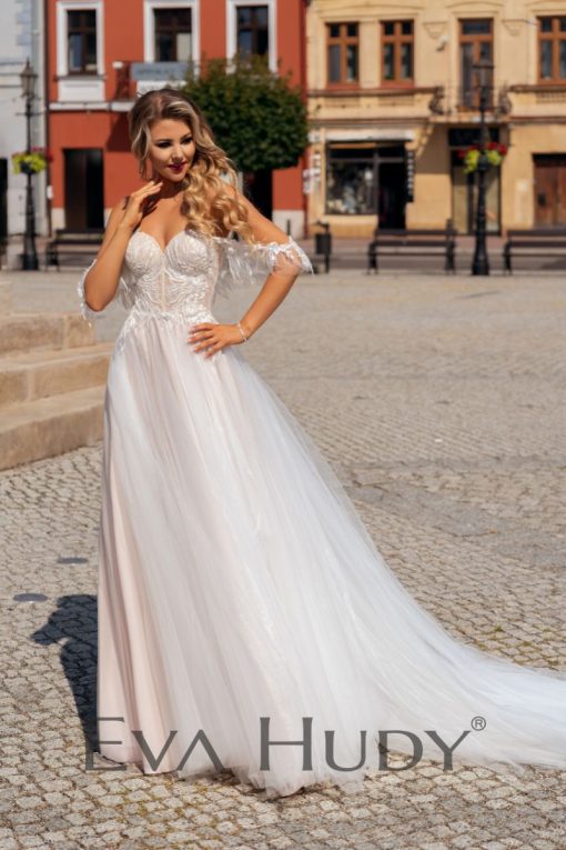 Lekka i subtelna suknia w delikatnym odcieniu nude z romantycznie opadającymi ramiączkami. Posiada pięknie wykończoną górę oraz zwiewny, tiulowy dół.