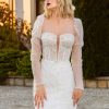Elegancka i pełna blasku suknia w fasonie rybki. Perfekcyjnie eksponuje ciało. Posiada zjawiskowy tren oraz zdobione rękawki.