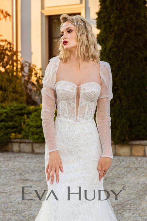 Elegancka i pełna blasku suknia w fasonie rybki. Perfekcyjnie eksponuje ciało. Posiada zjawiskowy tren oraz zdobione rękawki.