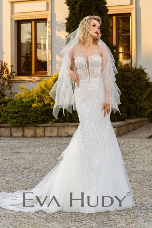 Elegancka i pełna blasku suknia w fasonie rybki. Perfekcyjnie eksponuje ciało. Posiada zjawiskowy tren oraz zdobione rękawki.