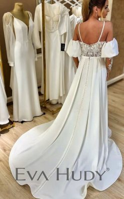 Elegancka suknia o prostej, ponadczasowej formie. Wyjątkowym akcentem są misternie wykonane rękawki, które są dopełnieniem prostej formy.
