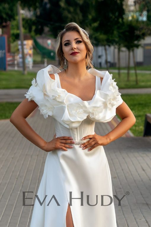 Elegancka i gładka suknia ślubna o ponadczasowym kroju klasycznej litery A, która zachwyca swoją prostą formą i minimalistycznym wykończeniem.