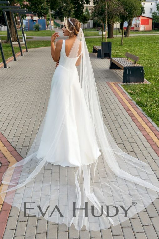 Elegancka i gładka suknia ślubna o ponadczasowym kroju klasycznej litery A, która zachwyca swoją prostą formą i minimalistycznym wykończeniem.