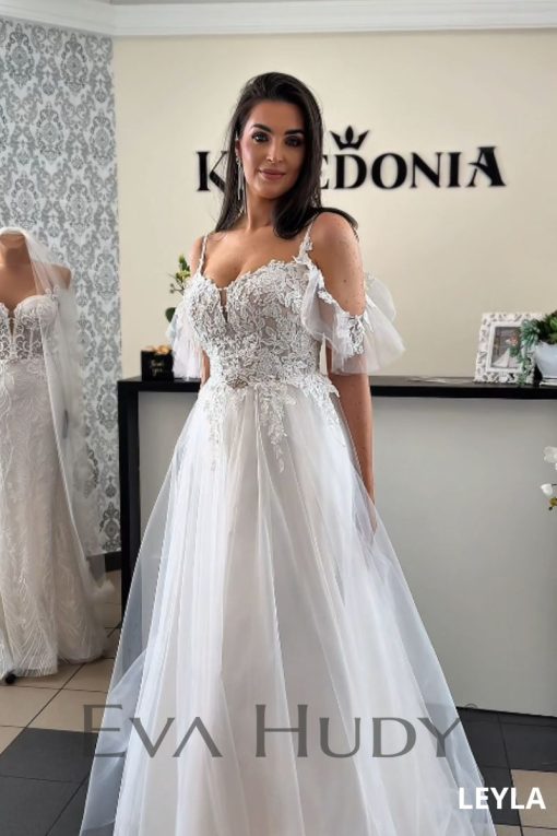 To lekka i romantyczna suknia ślubna o kroju litery A,. Lekka forma dolnej części doskonale równoważy bardziej zdobną górę.
