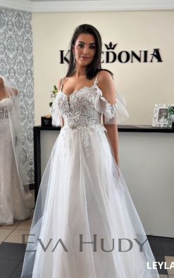 LEYLA to lekka i romantyczna suknia ślubna o kroju litery A, która zachwyca swoją subtelnością, wdziękiem i finezją wykonania. Lekka forma dolnej części doskonale równoważy bardziej zdobną górę, a ich połączenie tworzy harmonijny, kunsztowny efekt.