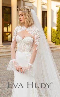 Kobieca suknia ślubna o fasonie rybki. Połączenie zdobionej góry z minimalistycznym dołem sprawia, że całość prezentuje się elegancko i nowocześnie.