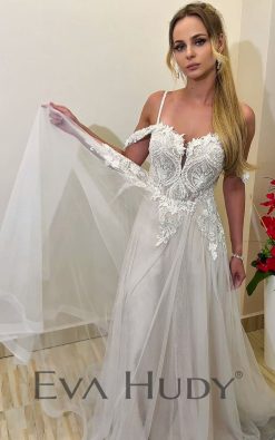 Romantyczna suknia ślubna o kroju litery A. Jej zwiewny dół idealnie współgra ze zdobną górą, a ich połączenie tworzy harmonijną i elegancką kompozycję. Dopełnieniem tej stylizacji jest zjawiskowy tren.