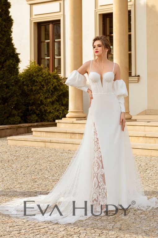 Subtelna suknia o niezwykle kobiecym charakterze. Góra sukni przyciąga uwagę swoją elegancją. Posiada rękawy dopasowane, zakończone subtelnymi bufkami.